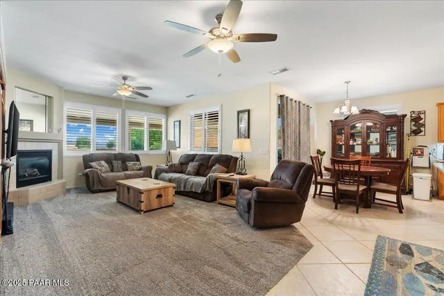 a living room with furniture kitchen view and a chandelier