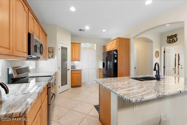 a kitchen with stainless steel appliances granite countertop a sink and cabinets