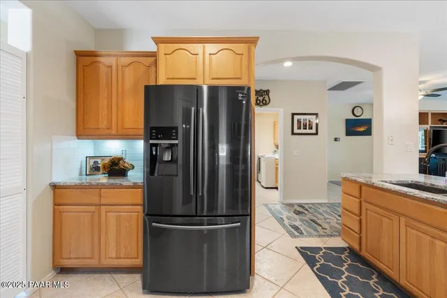 a kitchen with stainless steel appliances granite countertop a refrigerator and a stove top oven