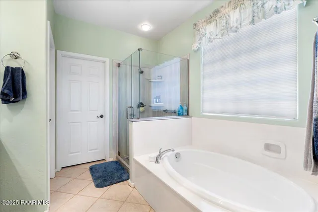 a bathroom with a tub shower and mirror