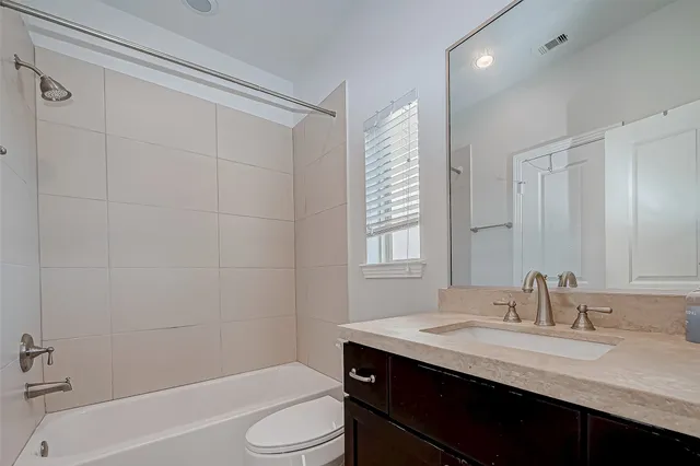 a bathroom with a granite countertop sink toilet a mirror and shower