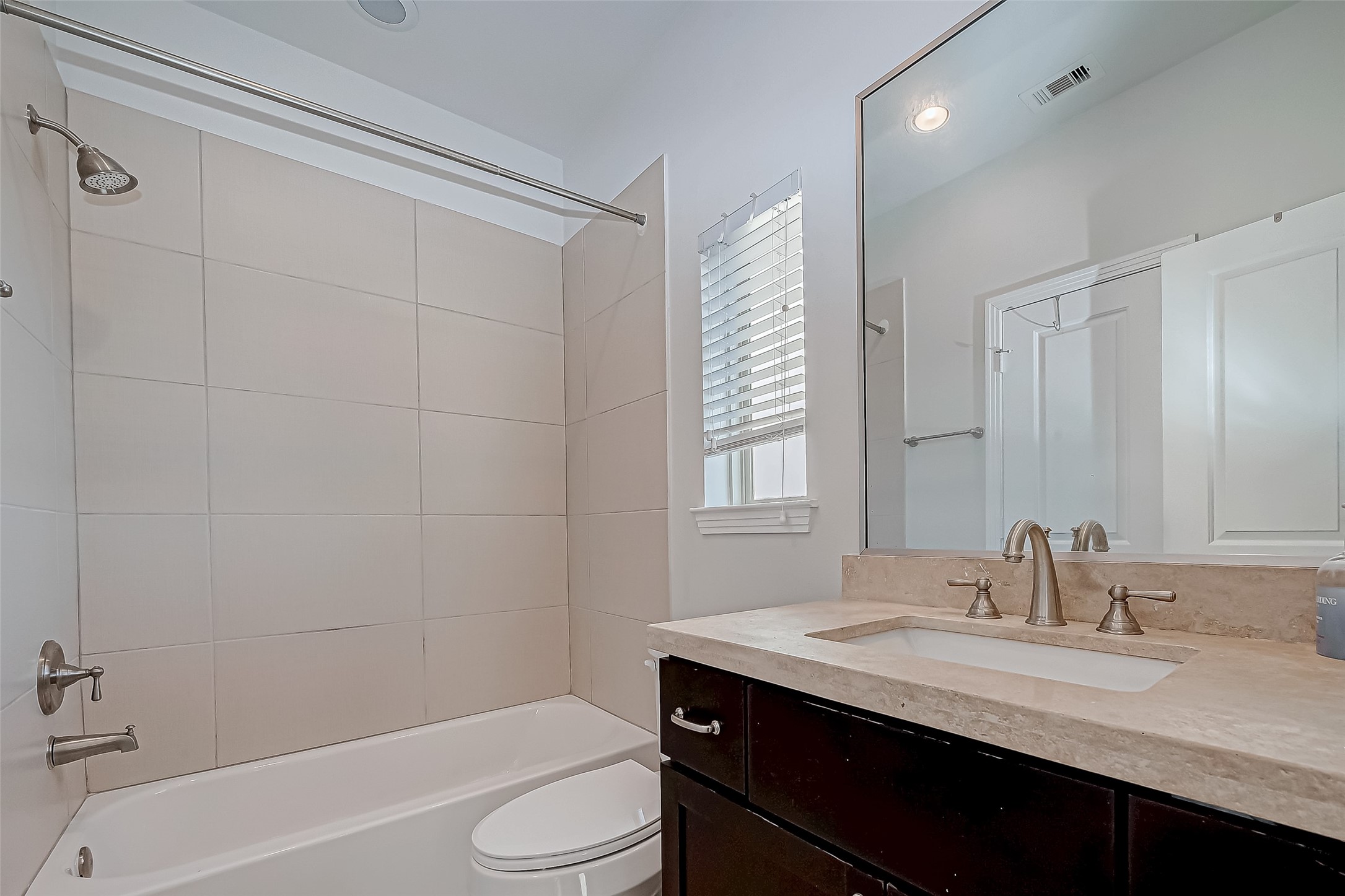 2227 Chenevert Street Houston, TX 77003 - Photo 21 of 24 a bathroom with a granite countertop sink toilet a mirror and shower