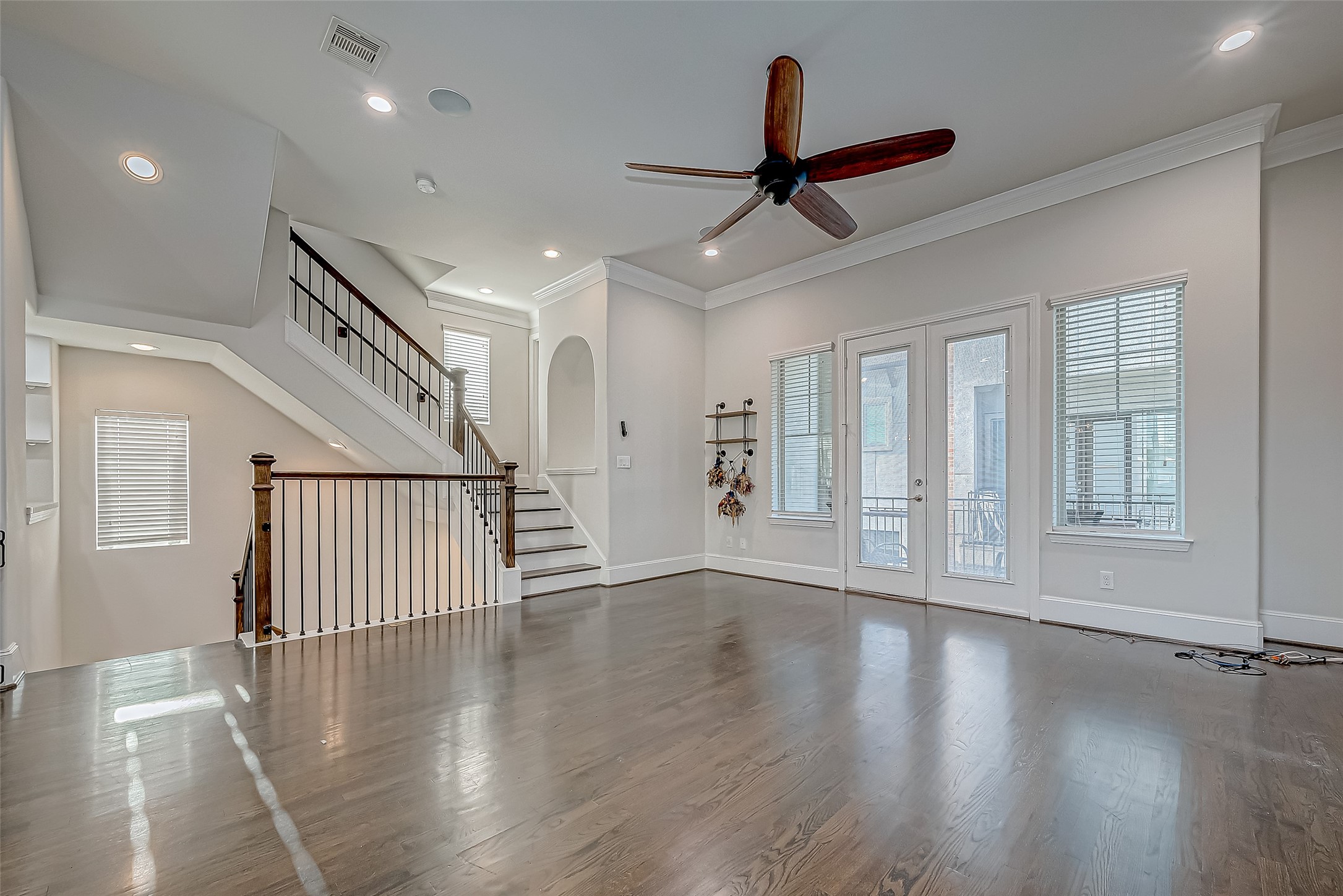 2227 Chenevert Street Houston, TX 77003 - Photo 5 of 24 a view of an empty room with wooden floor ceiling fan and windows