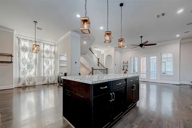 a kitchen with stainless steel appliances granite countertop a sink a refrigerator and wooden floor