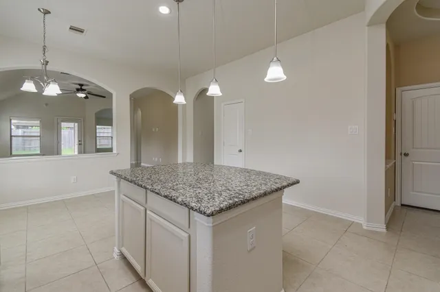 a kitchen with a sink chandelier and refrigerator