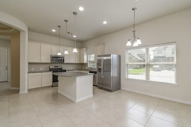 a kitchen with refrigerator and window