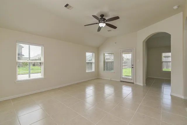a view of an empty room with window and wooden floor