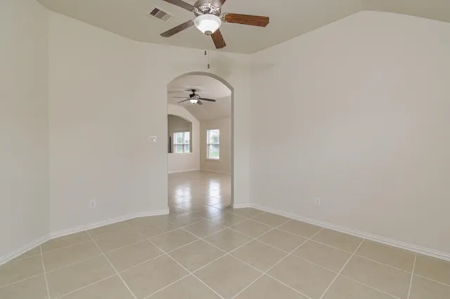 an empty room with closet and a ceiling fan