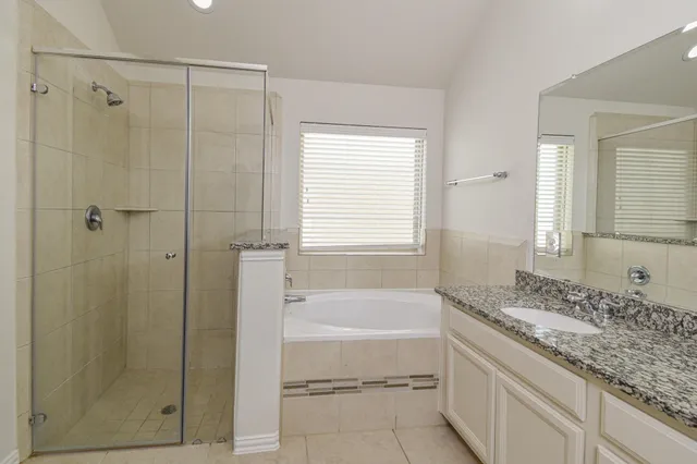 a bathroom with a tub shower and a sink