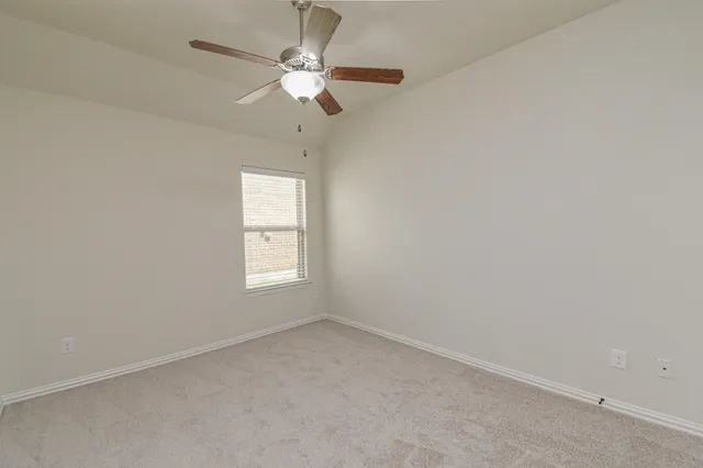 an empty room with a fan and a fan
