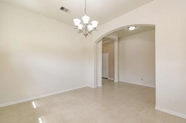 a view of an empty room with a chandelier