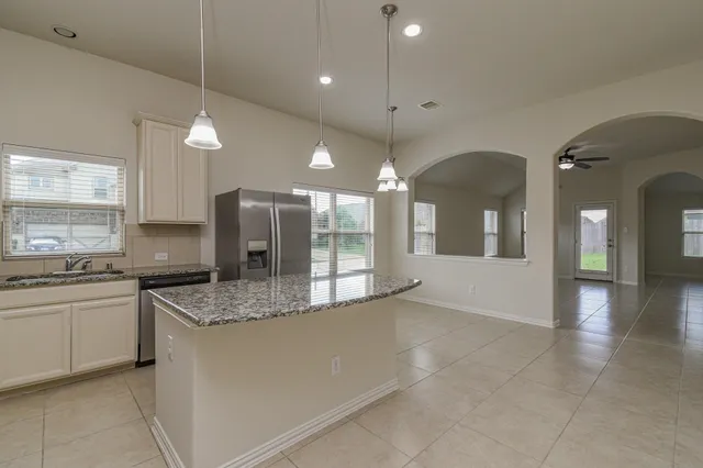 a kitchen with stainless steel appliances granite countertop a sink a stove and a refrigerator