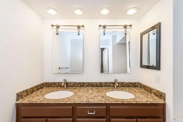 a bathroom with a granite countertop sink and a mirror