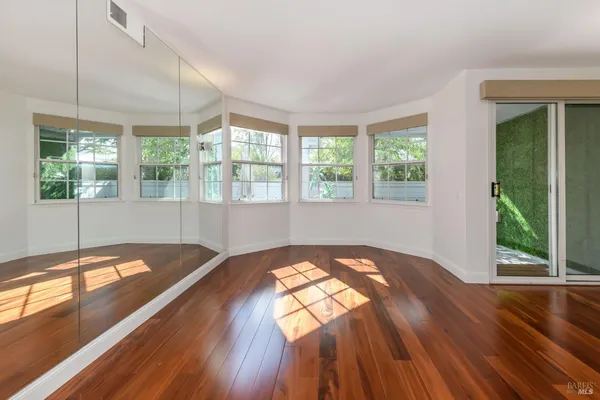 a view of a bedroom with wooden floor and a floor to ceiling window