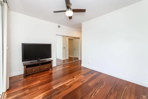a view of livingroom with wooden floor and a flat screen tv
