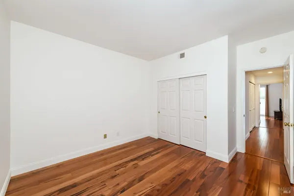 a view of a room with wooden floor and white walls