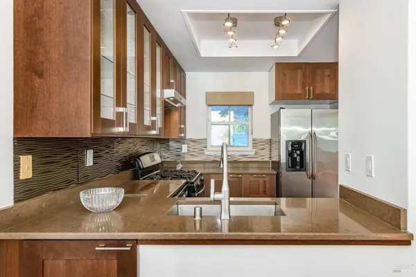 a kitchen with sink a stove and cabinets