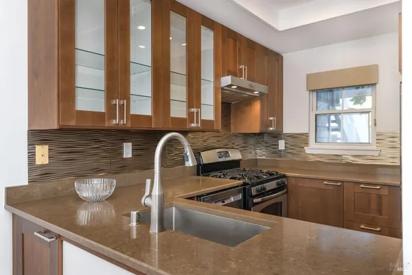 a kitchen with stainless steel appliances granite countertop a sink and a stove