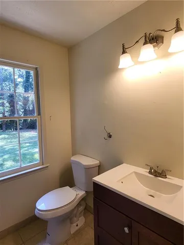 a bathroom with a toilet a sink and a large mirror