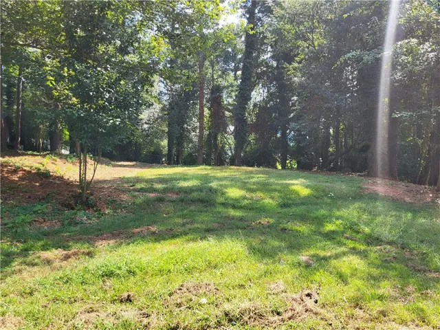 a backyard of a house with lots of green space and fountain