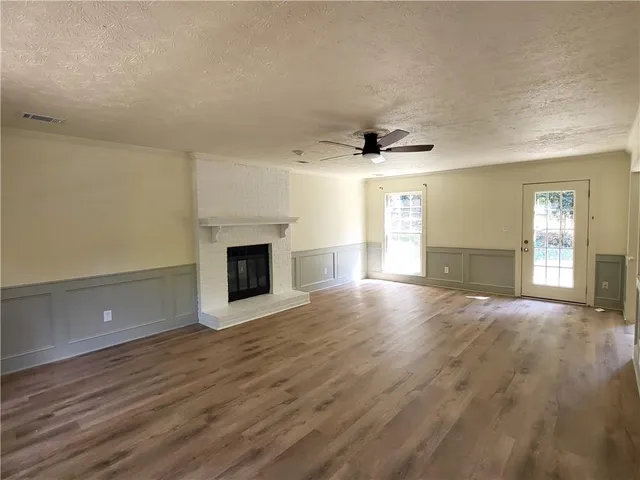 an empty room with wooden floor and fireplace
