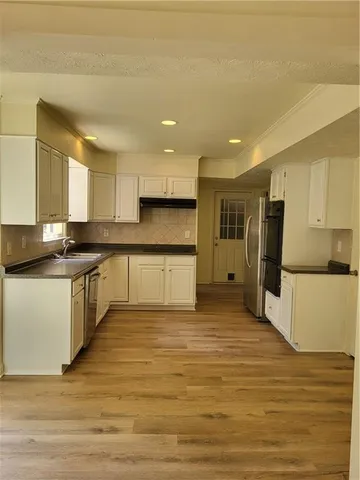 a kitchen with stainless steel appliances granite countertop a stove a sink and a refrigerator