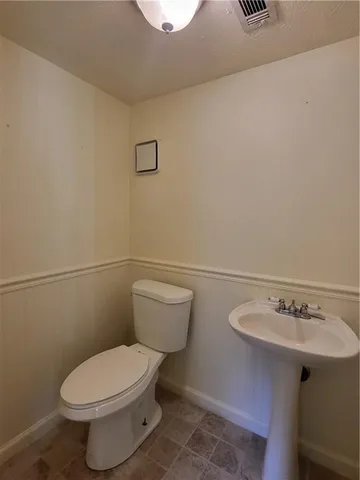 a white toilet sitting next to a bathroom sink