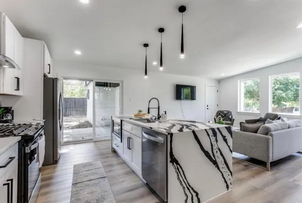a open kitchen with stainless steel appliances granite countertop a stove and a sink
