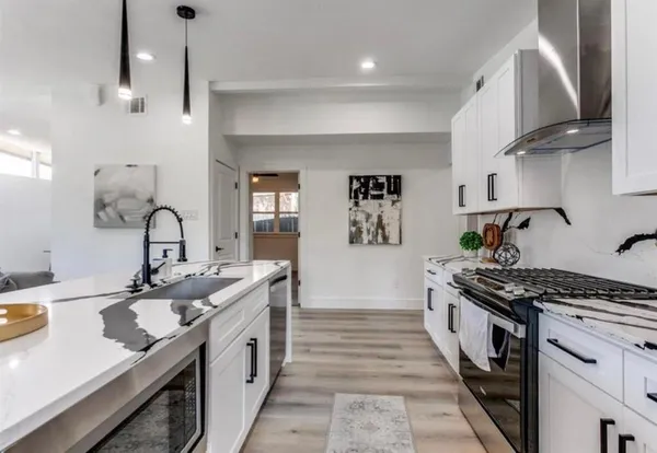 a kitchen with stainless steel appliances granite countertop a sink stove and cabinets
