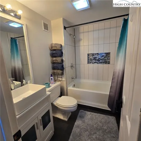 a bathroom with a sink a toilet a tub and shower