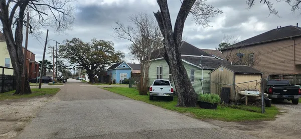 a view of a house with a yard and large trees