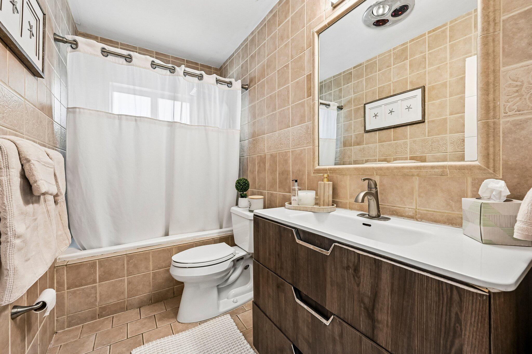 2940 Northeast 39th Court Lighthouse Point, FL 33064 - Photo 28 of 42 a bathroom with a sink a toilet and a large mirror