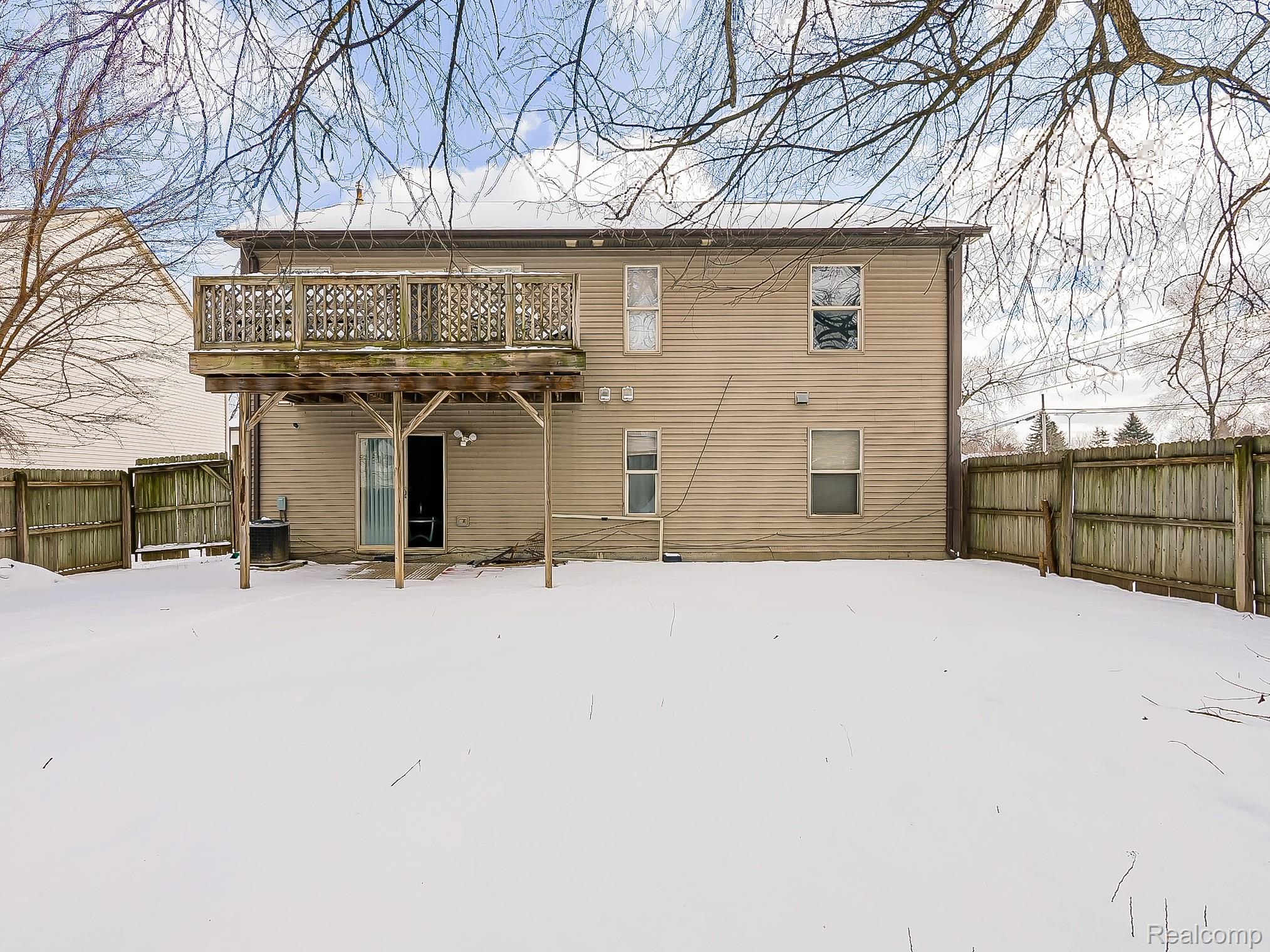 34460 Van Born Road Wayne, MI 48184 - Photo 27 of 31 Snow covered back of property featuring a fenced backyard, a wooden deck, and a patio