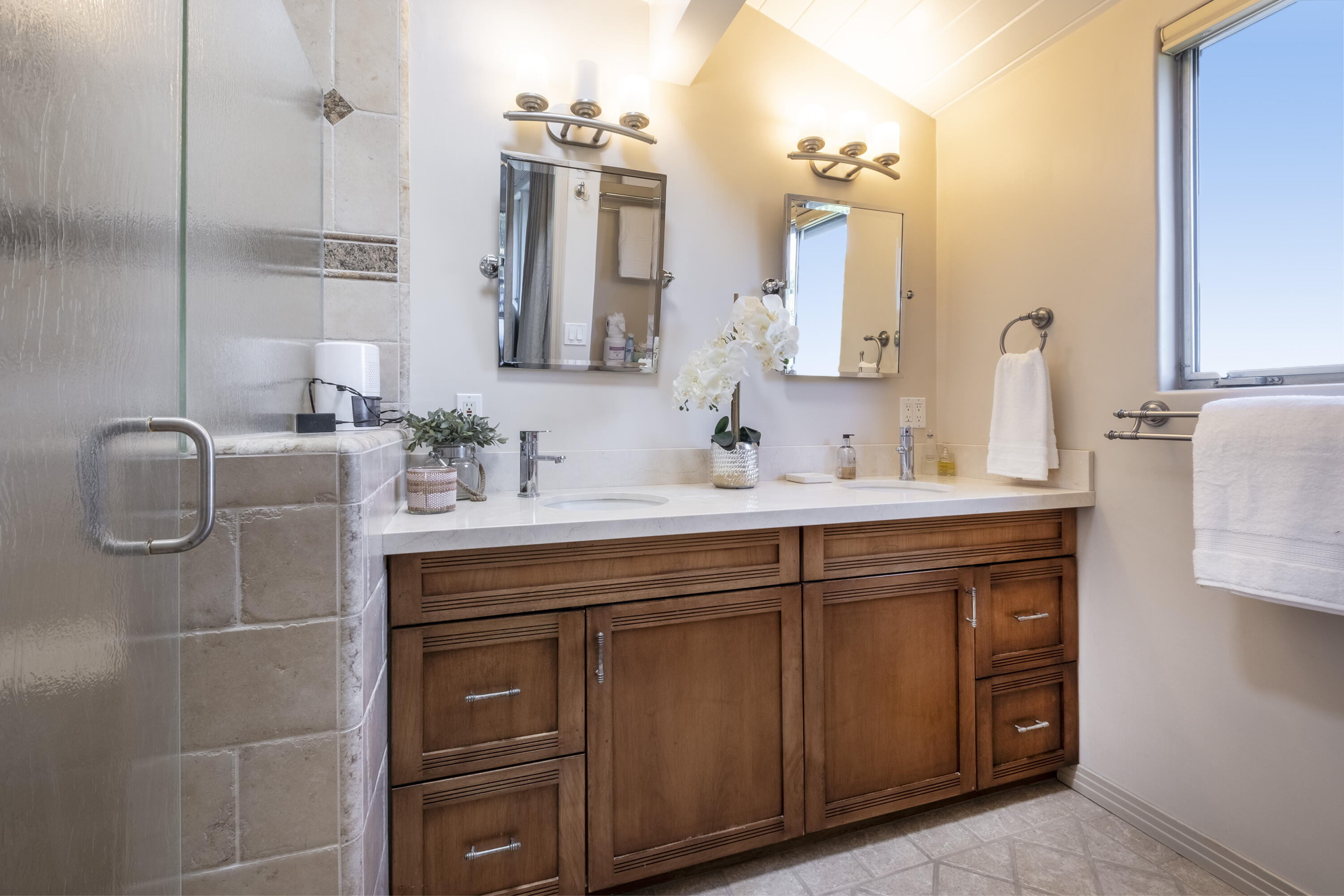 985 Monte Drive Santa Barbara, CA 93110 - Photo 11 of 29 a bathroom with a double vanity sink a mirror and shower