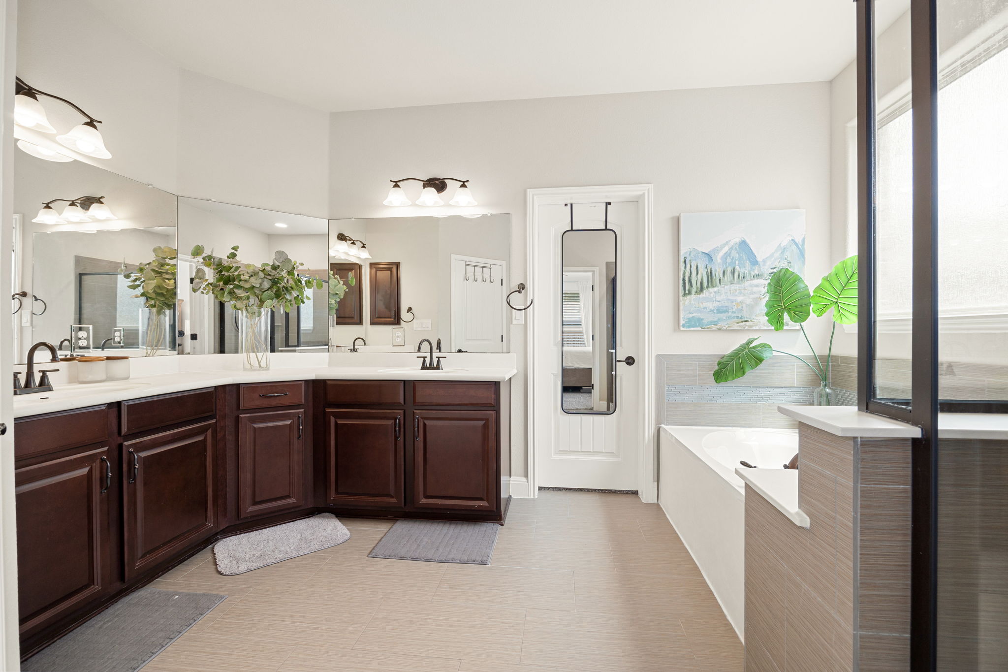 225 Pettigrew Path Buda, TX 78610 - Photo 18 of 38 a large bathroom with a double vanity sink a large mirror and a bathtub