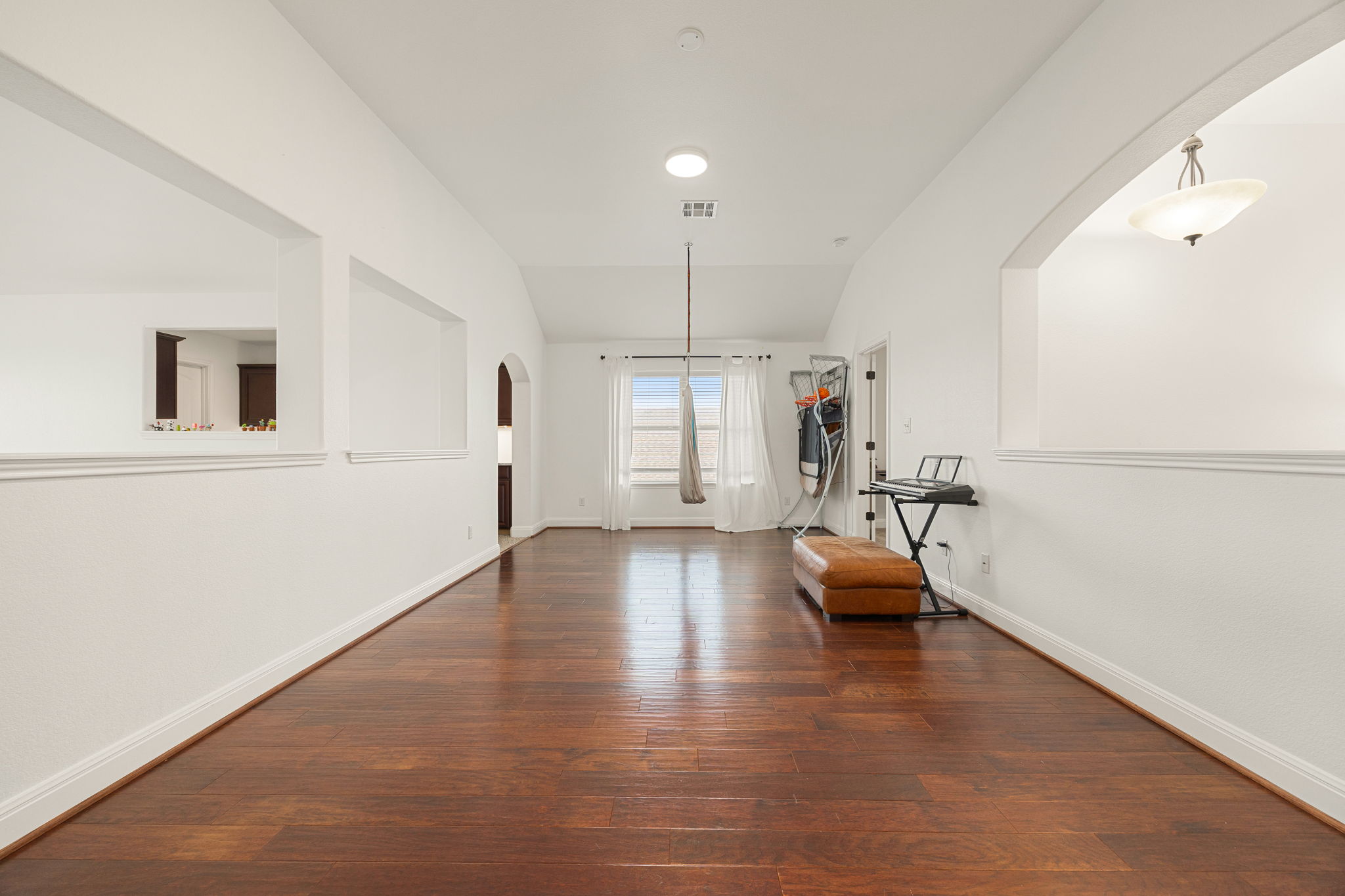 225 Pettigrew Path Buda, TX 78610 - Photo 20 of 38 a hallway with a couch and chandelier