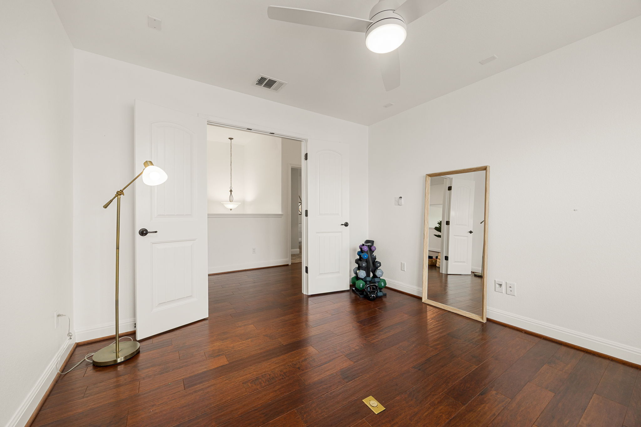 225 Pettigrew Path Buda, TX 78610 - Photo 23 of 38 an empty room with wooden floor and a ceiling fan