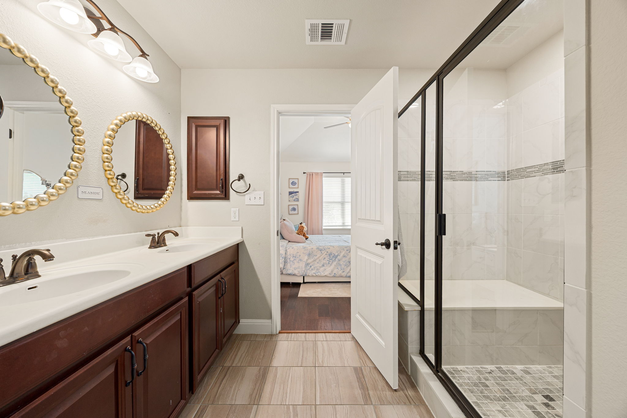 225 Pettigrew Path Buda, TX 78610 - Photo 26 of 38 a bathroom with a double vanity sink mirror and shower