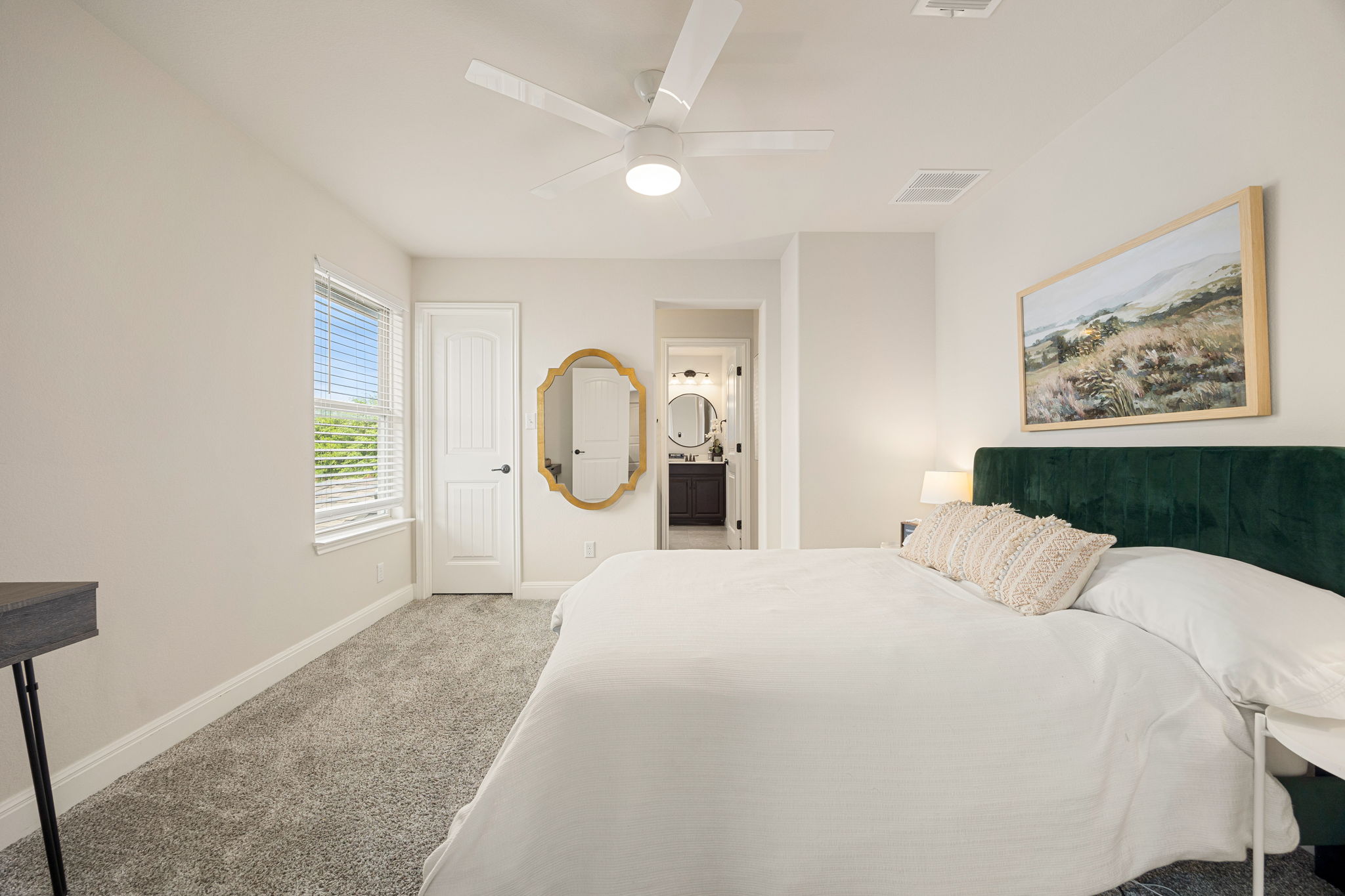 225 Pettigrew Path Buda, TX 78610 - Photo 27 of 38 a bedroom with a large bed and a chandelier