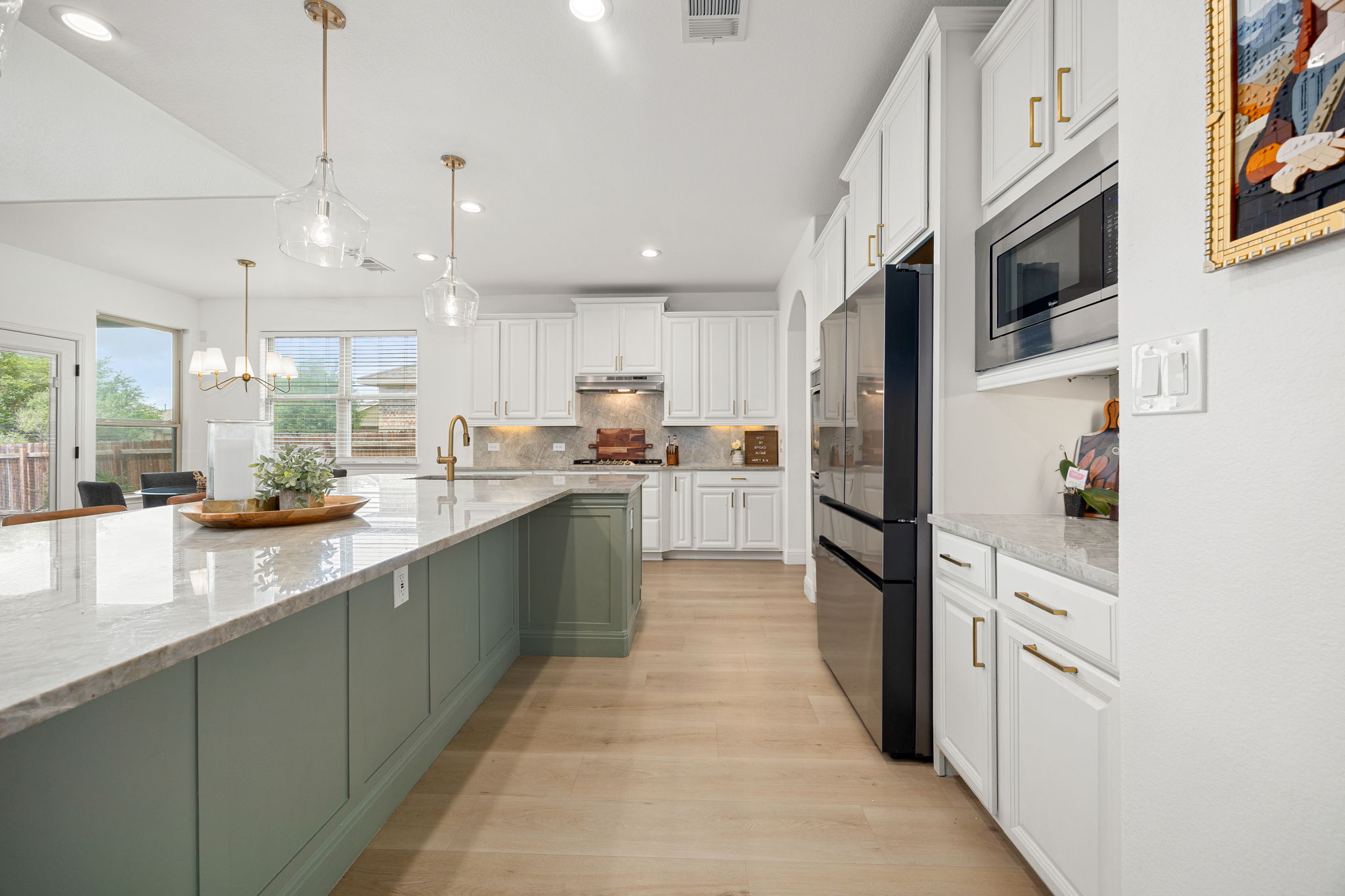 225 Pettigrew Path Buda, TX 78610 - Photo 10 of 38 a kitchen with stainless steel appliances granite countertop a refrigerator a sink dishwasher a oven with white cabinets and wooden floor