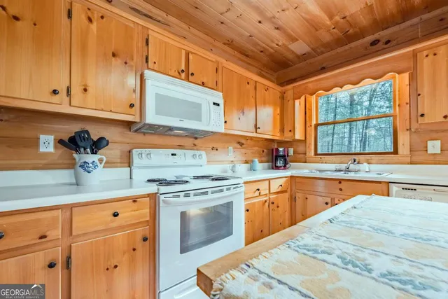 a kitchen with stainless steel appliances granite countertop a sink a stove and cabinets