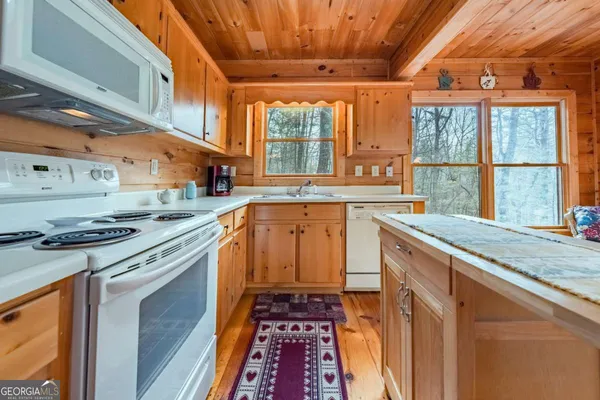 a kitchen with stainless steel appliances granite countertop a stove a sink and a granite counter tops with wooden floors