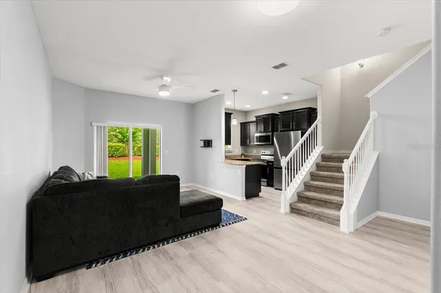 a living room with furniture and a wooden floor