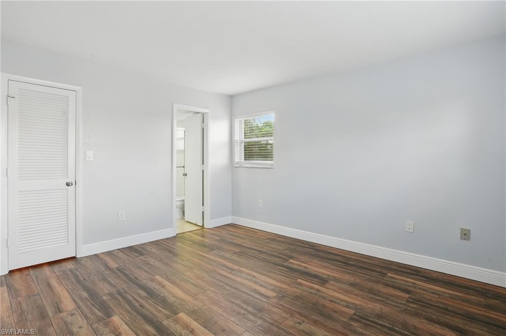170 Turtle Lake Court, Unit 301 Naples, FL 34105 - Photo 11 of 23 a view of an empty room with wooden floor and a window
