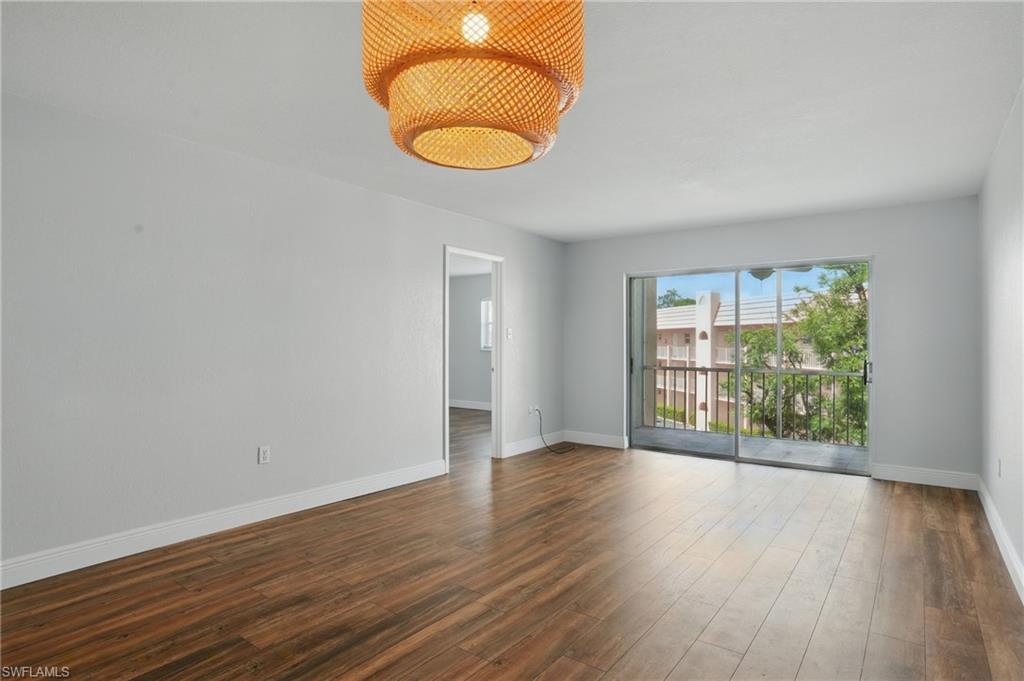 170 Turtle Lake Court, Unit 301 Naples, FL 34105 - Photo 2 of 23 an empty room with wooden floor and windows