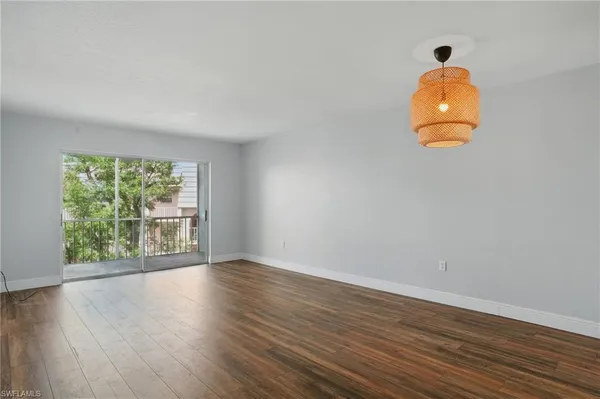 a room with wooden floor and windows