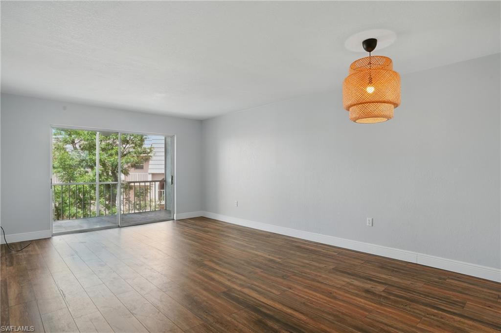 170 Turtle Lake Court, Unit 301 Naples, FL 34105 - Photo 3 of 23 a room with wooden floor and windows