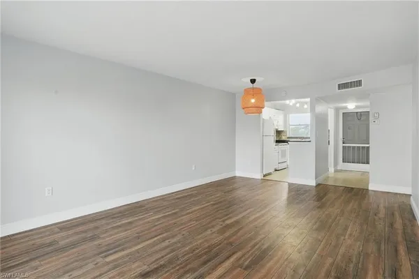 a view of empty room with wooden floor
