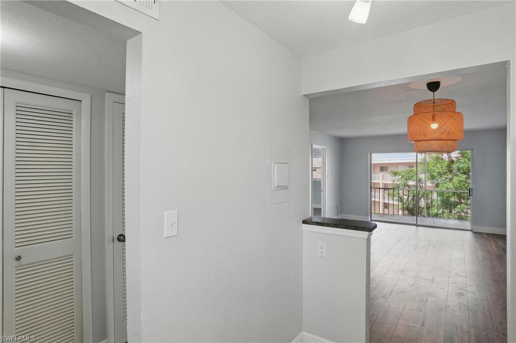170 Turtle Lake Court, Unit 301 Naples, FL 34105 - Photo 9 of 23 a view of a hallway with wooden floor and a dining table