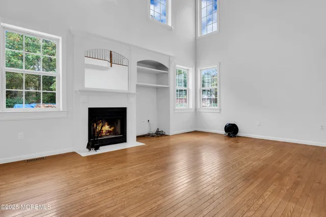 an empty room with windows and fireplace
